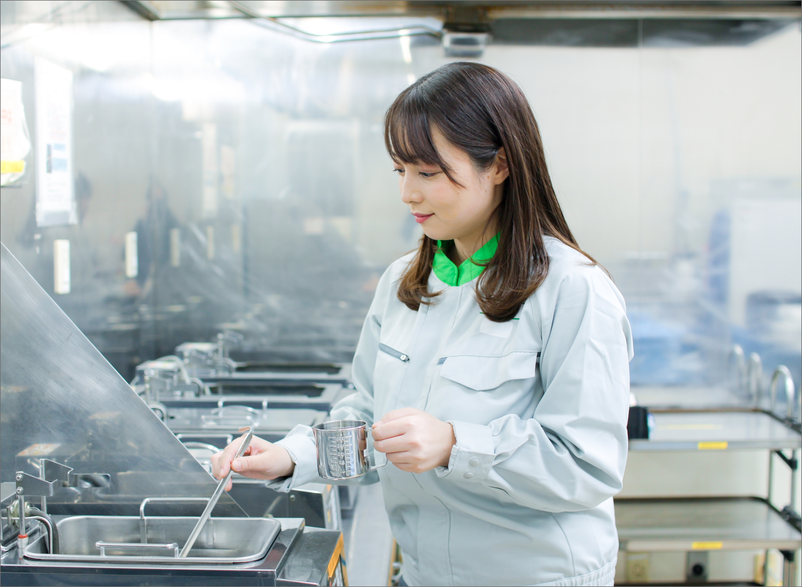 笑顔でエスカレーターに乗るJ-オイルミルズの男性社員