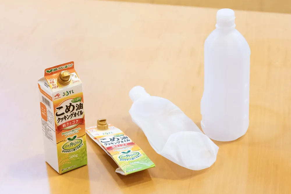 薄く小さく、つぶしたりたたんだりできる、J-オイルミルズの『スマートグリーンパック®』（左）と『エコボトル』（右）。