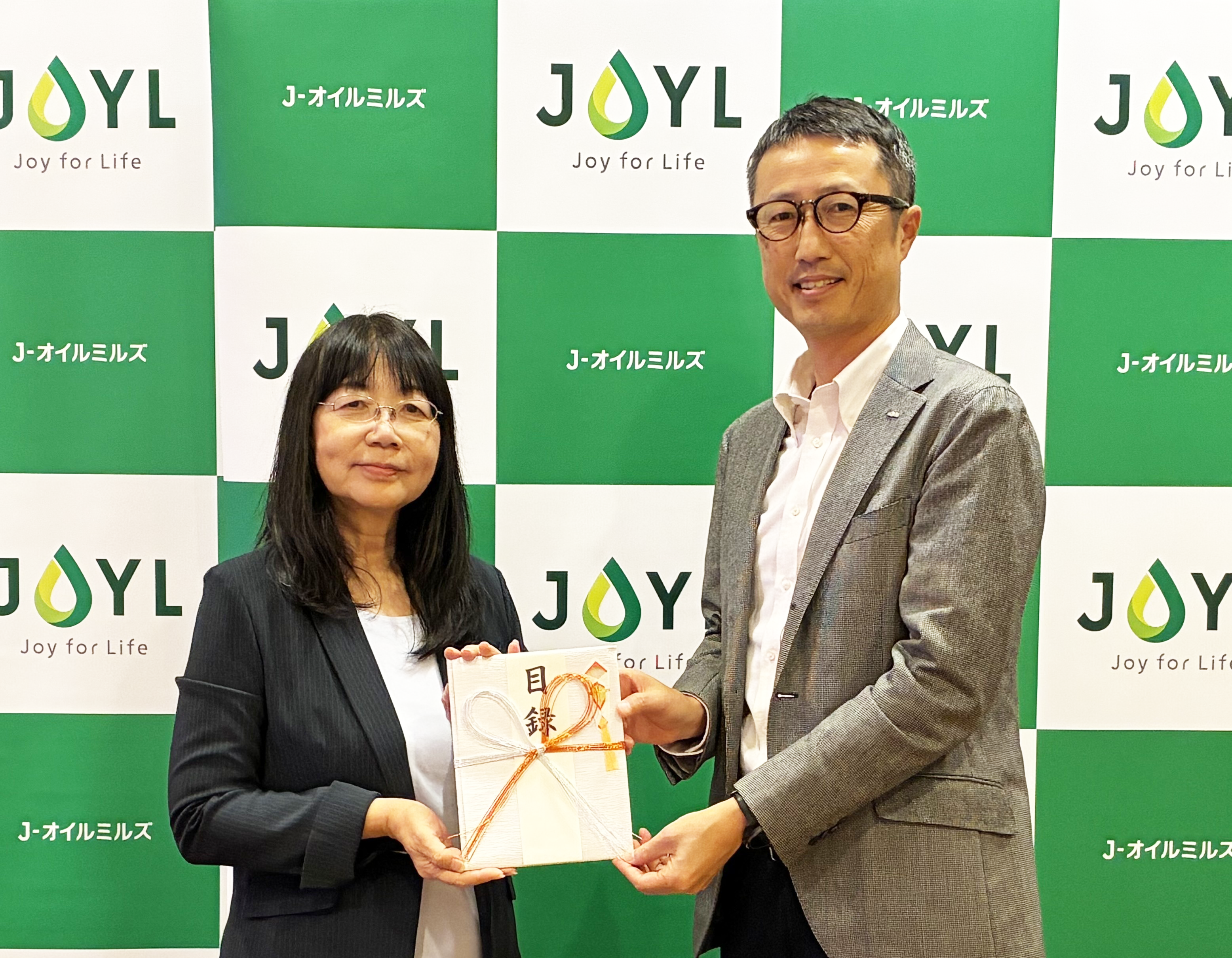JEAN  代表理事 吉野美子氏（左）、当社執行役員 マーケティング統括部長 佐藤 亮（右）＝10月21日、寄付金の贈呈式を開催